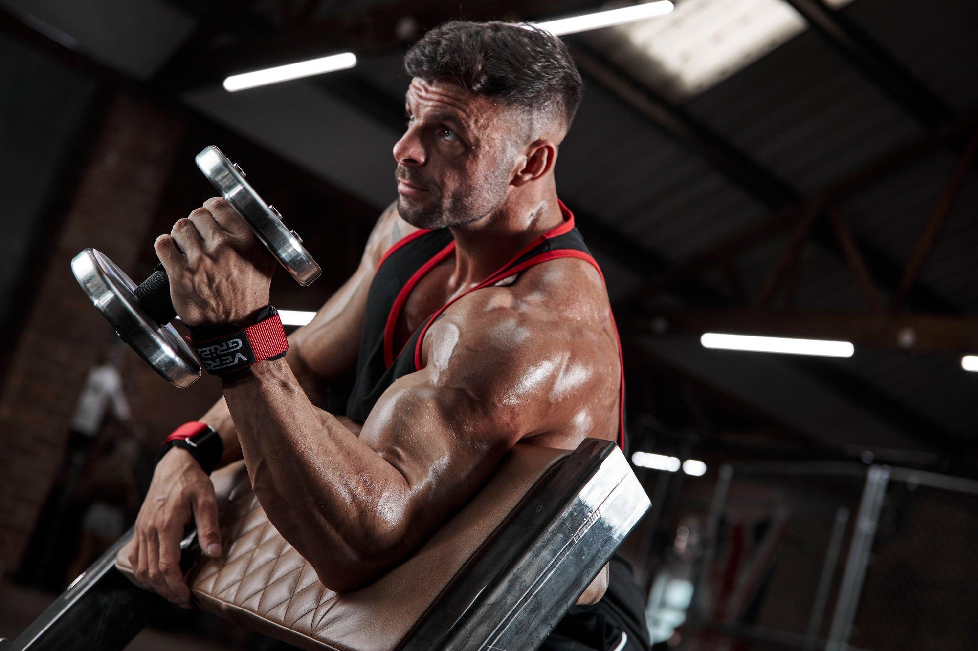 Man lifting weights using Versa Gripps during a workout